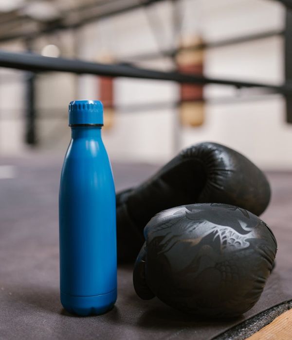 Close up of sports equipment and water bottle in a gym