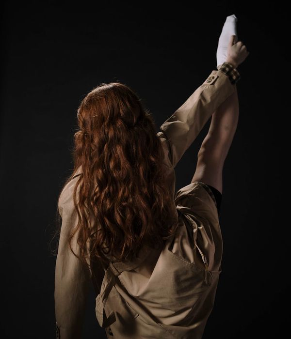 Woman performing light cardio movements in a modern dark studio